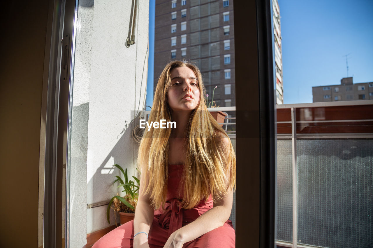 YOUNG WOMAN IN WINDOW