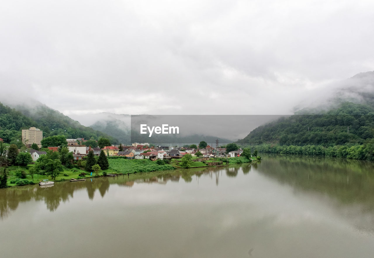 Scenic view of river by mountains against sky