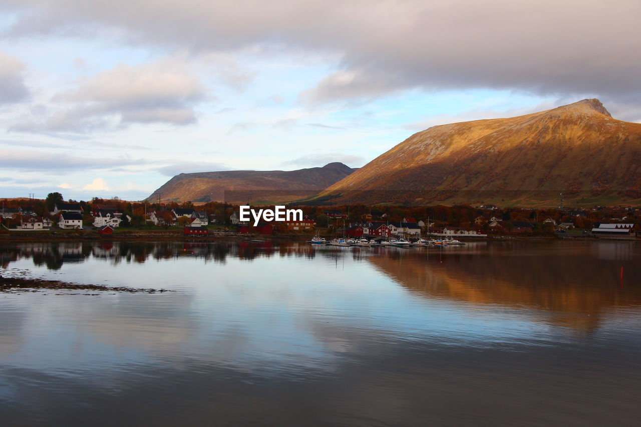 scenic view of lake by mountains against sky