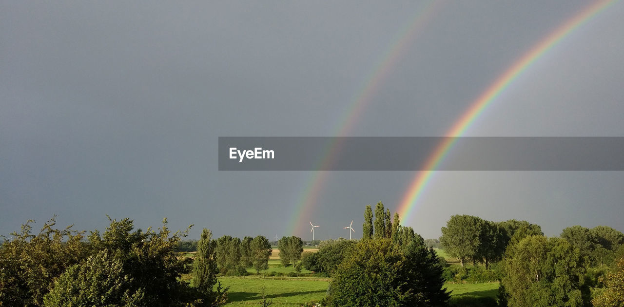 Scenic view of double rainbow over landscape against sky