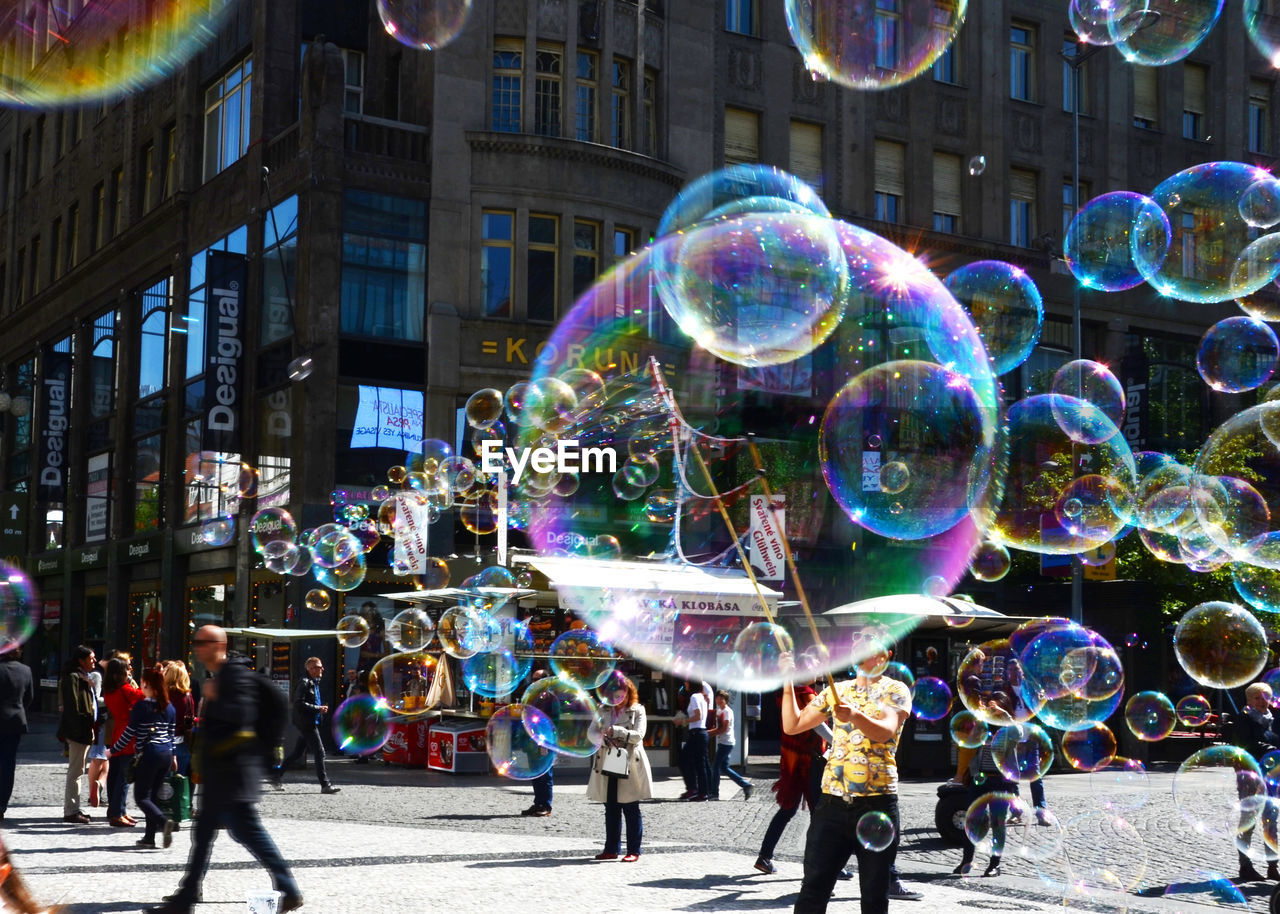 Bubbles with people on street in city