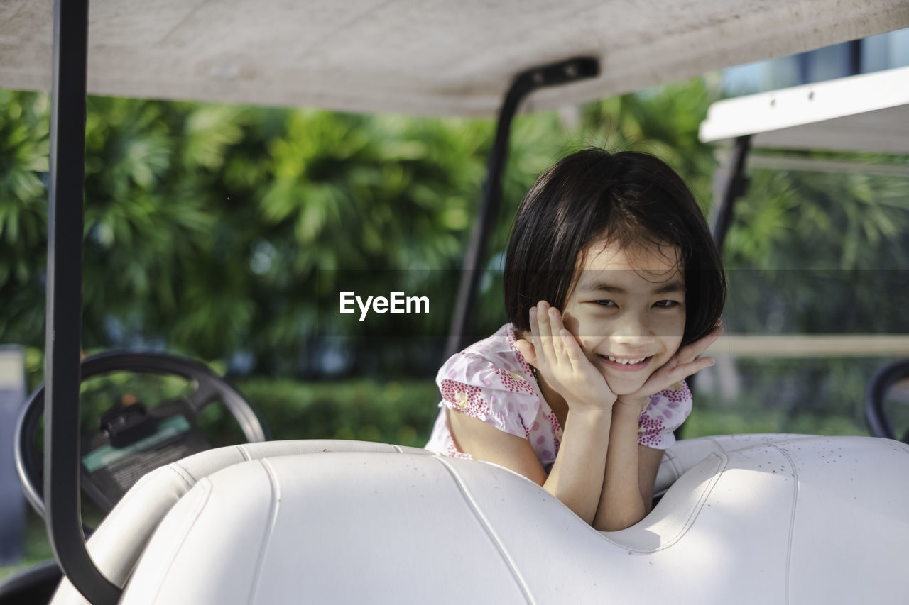 Portrait of smiling girl on golf cart