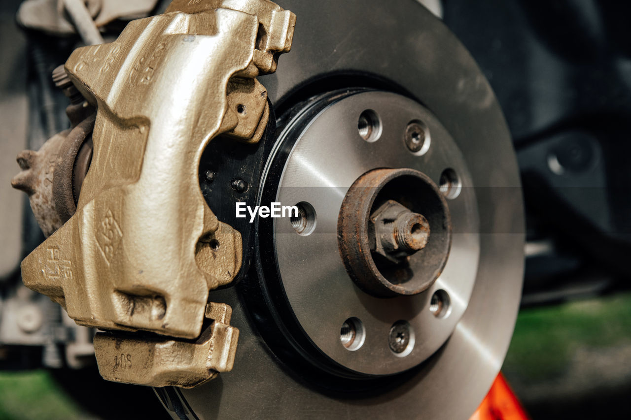 Close-up image of gold painted brake caliper on brake disc.