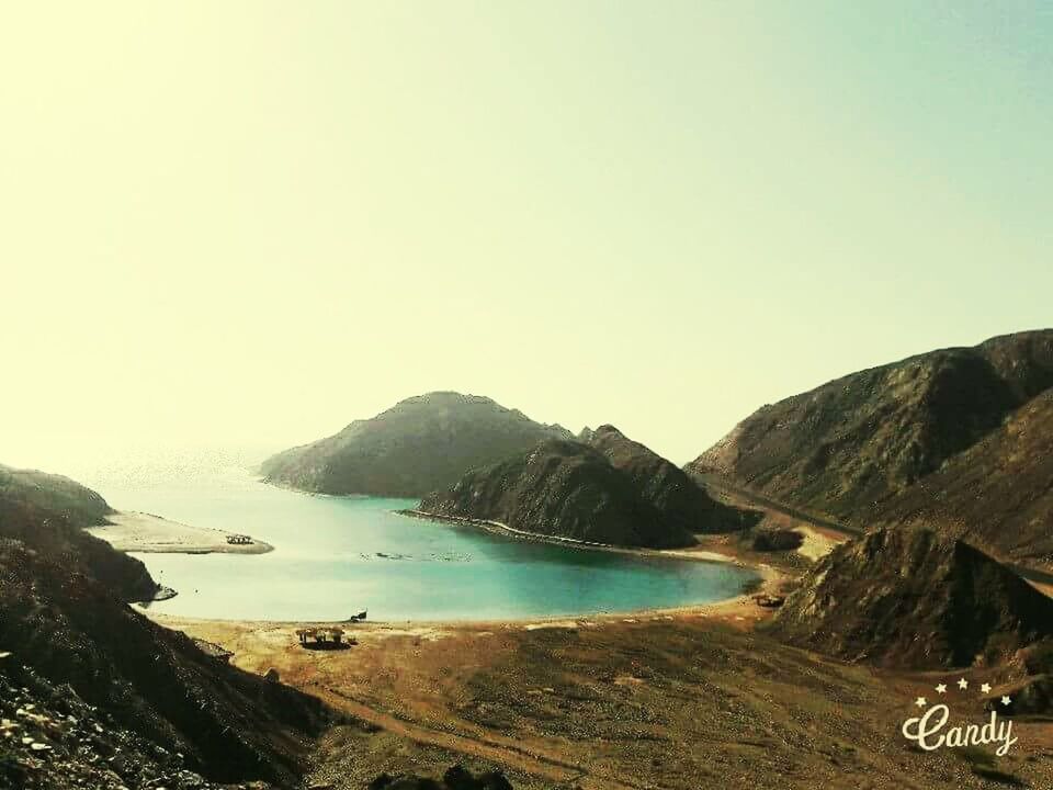 SCENIC VIEW OF SEA AND MOUNTAIN AGAINST CLEAR SKY