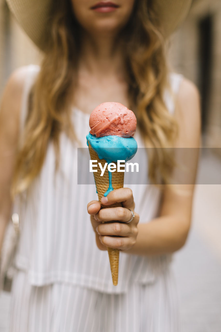 Woman holding melting ice cream cone