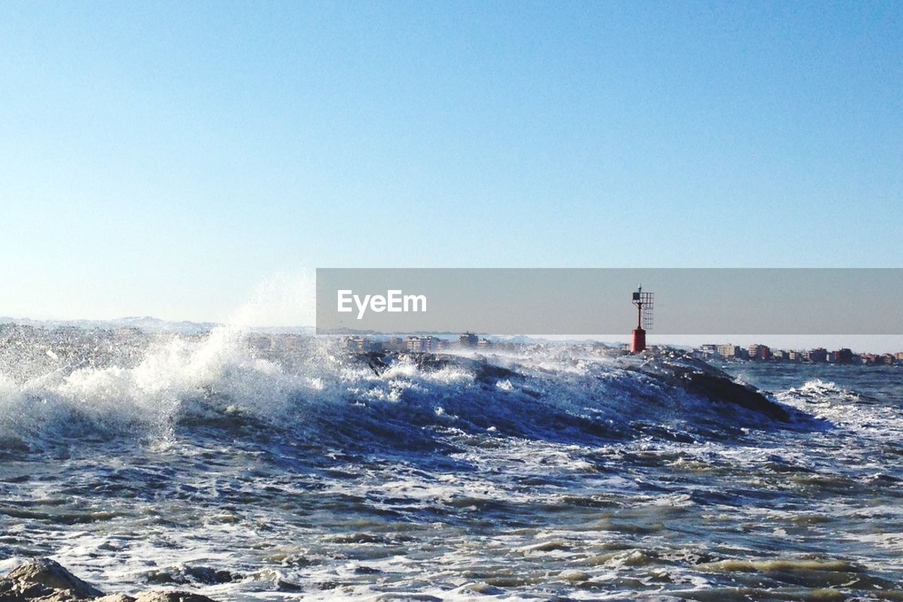 Sea waves against clear sky