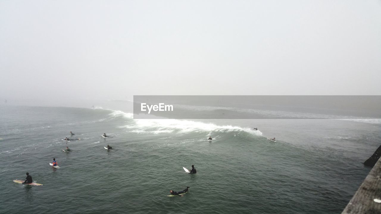 HIGH ANGLE VIEW OF DUCKS SWIMMING IN SEA