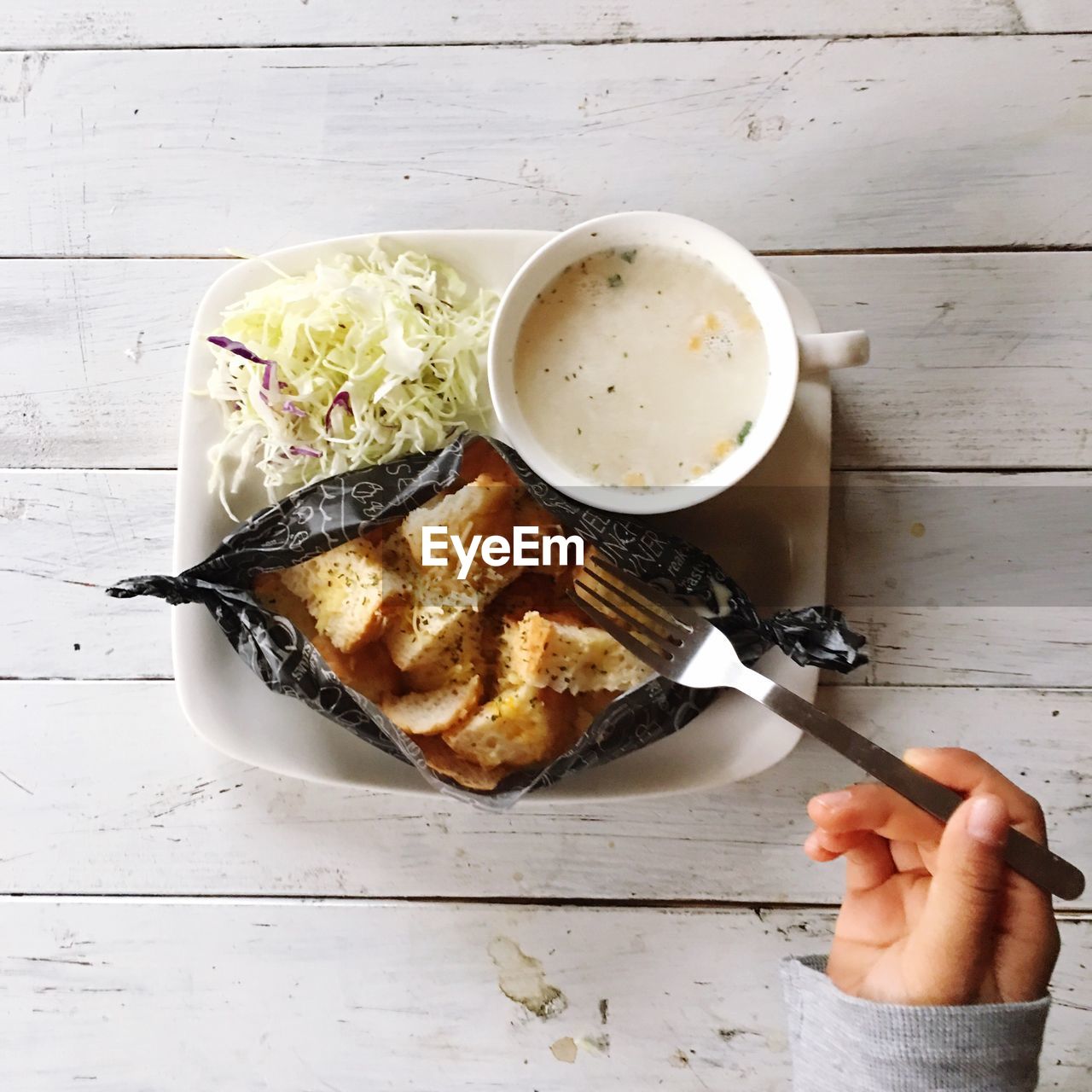 Cropped image of person having breakfast at table