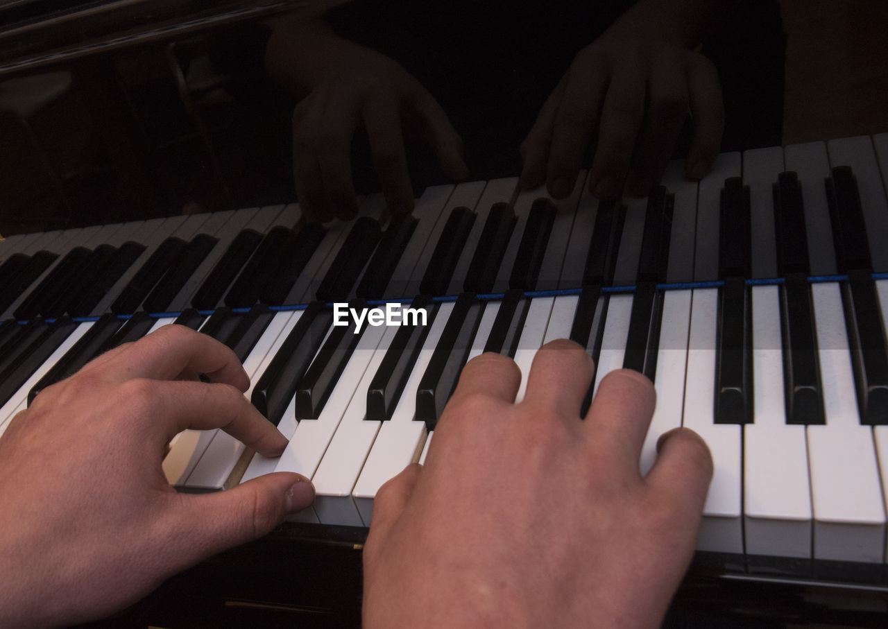 CROPPED IMAGE OF PERSON PLAYING PIANO AT HOME