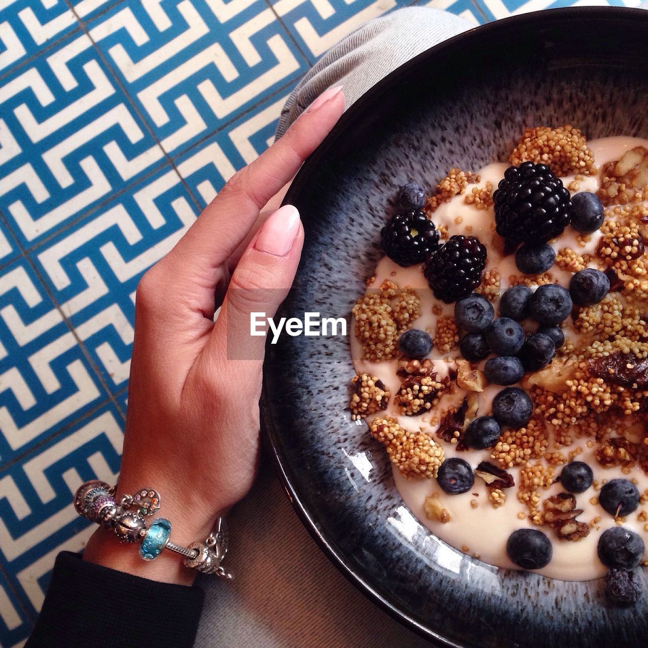 Cropped image of woman holding breakfast bowl at home