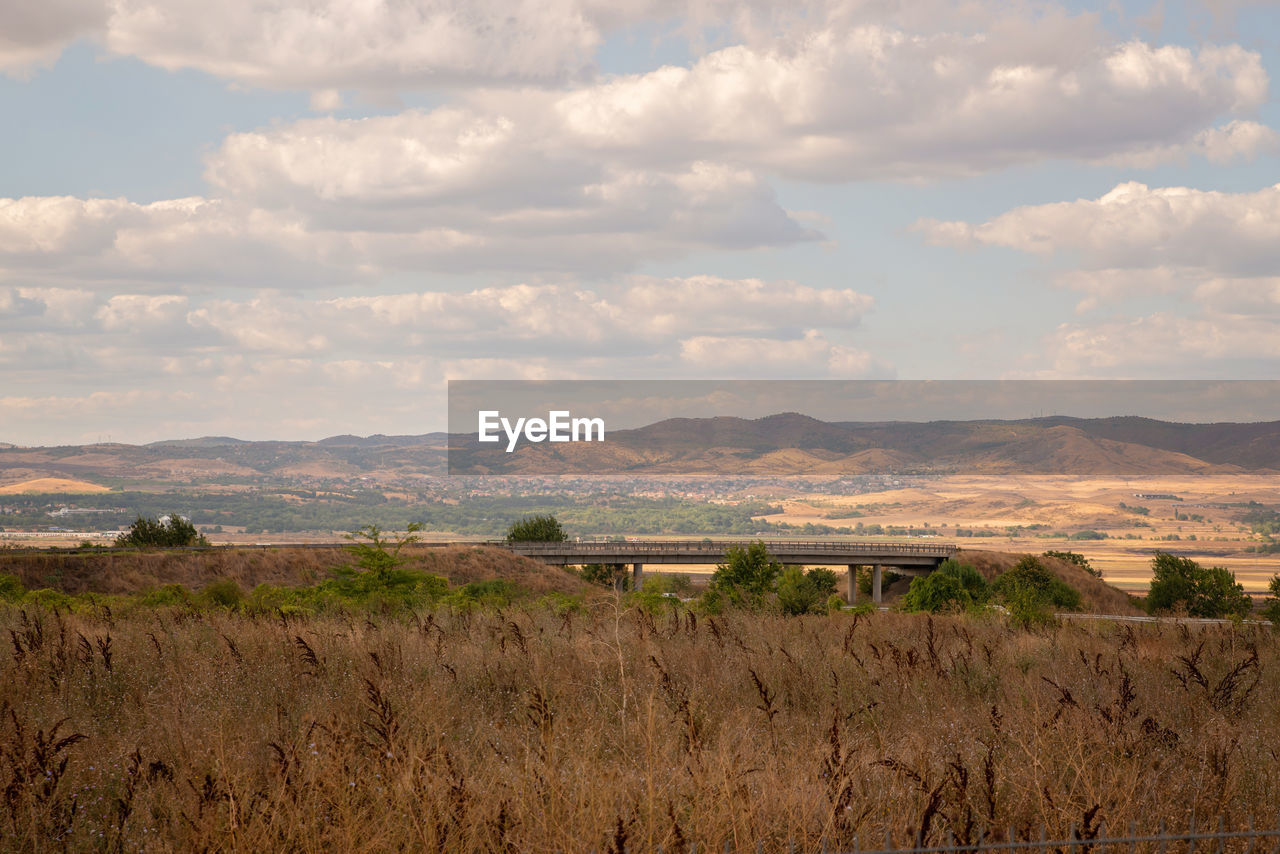 SCENIC VIEW OF LANDSCAPE AND MOUNTAINS AGAINST SKY