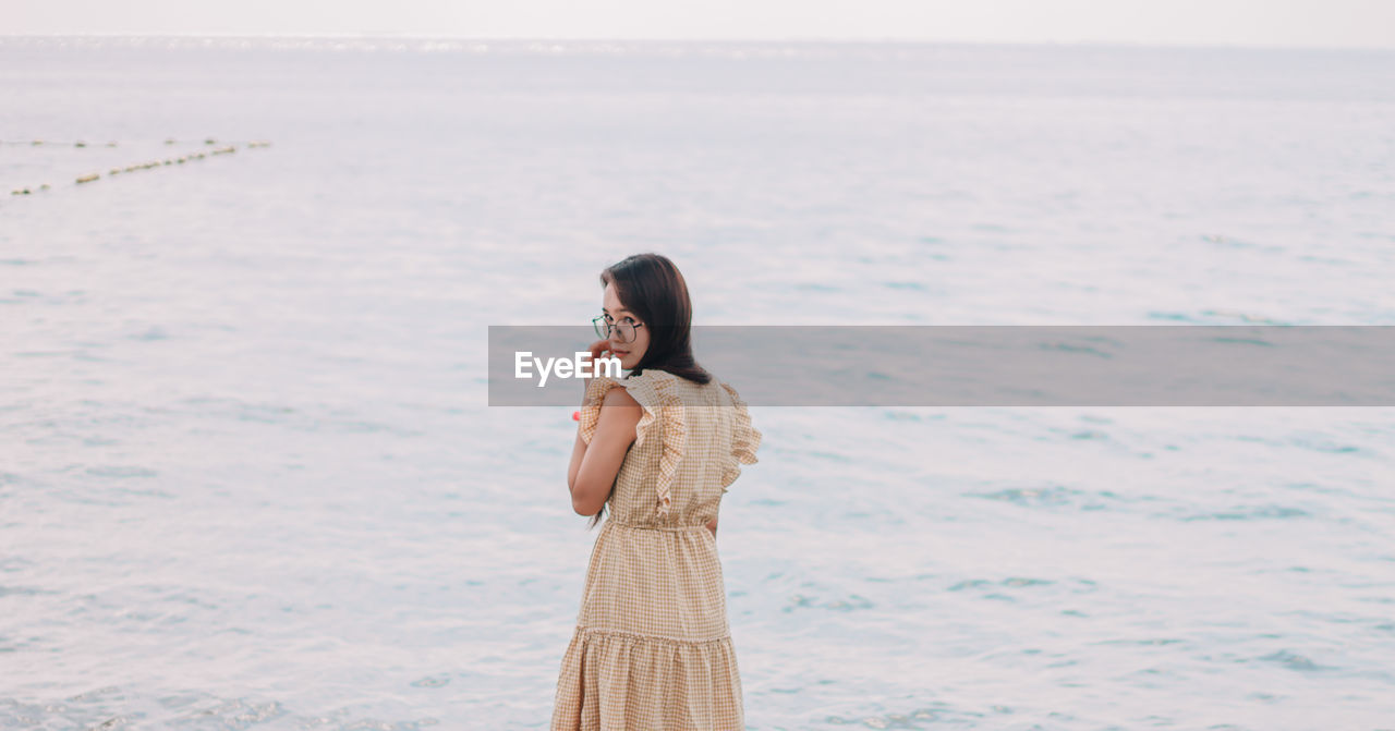 Full length of young woman standing on beach