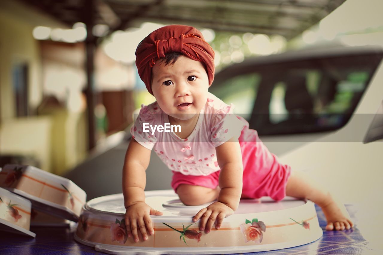 Portrait of cute baby girl on table