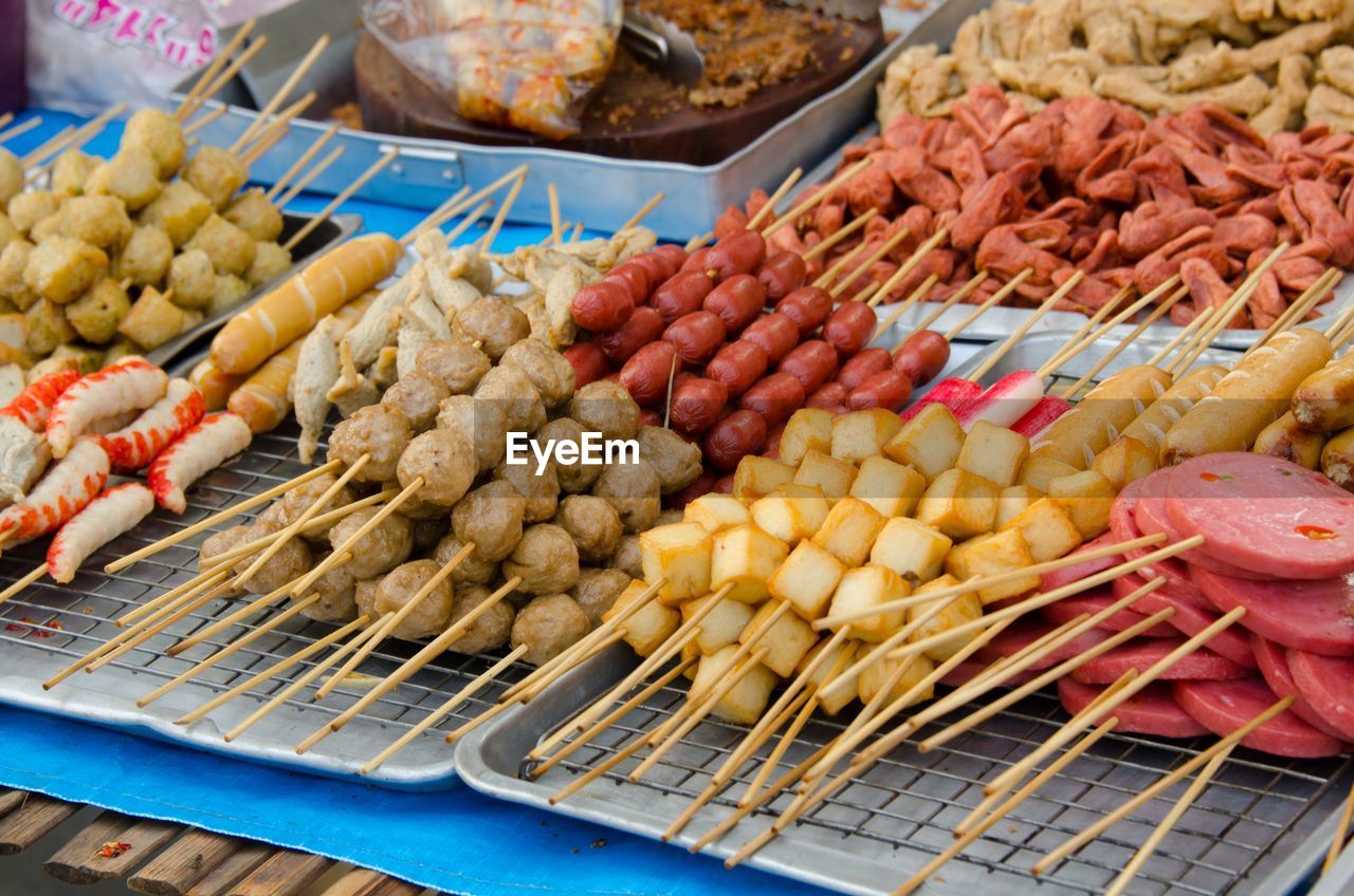 High angle view of fresh skewered food in tray at market stall