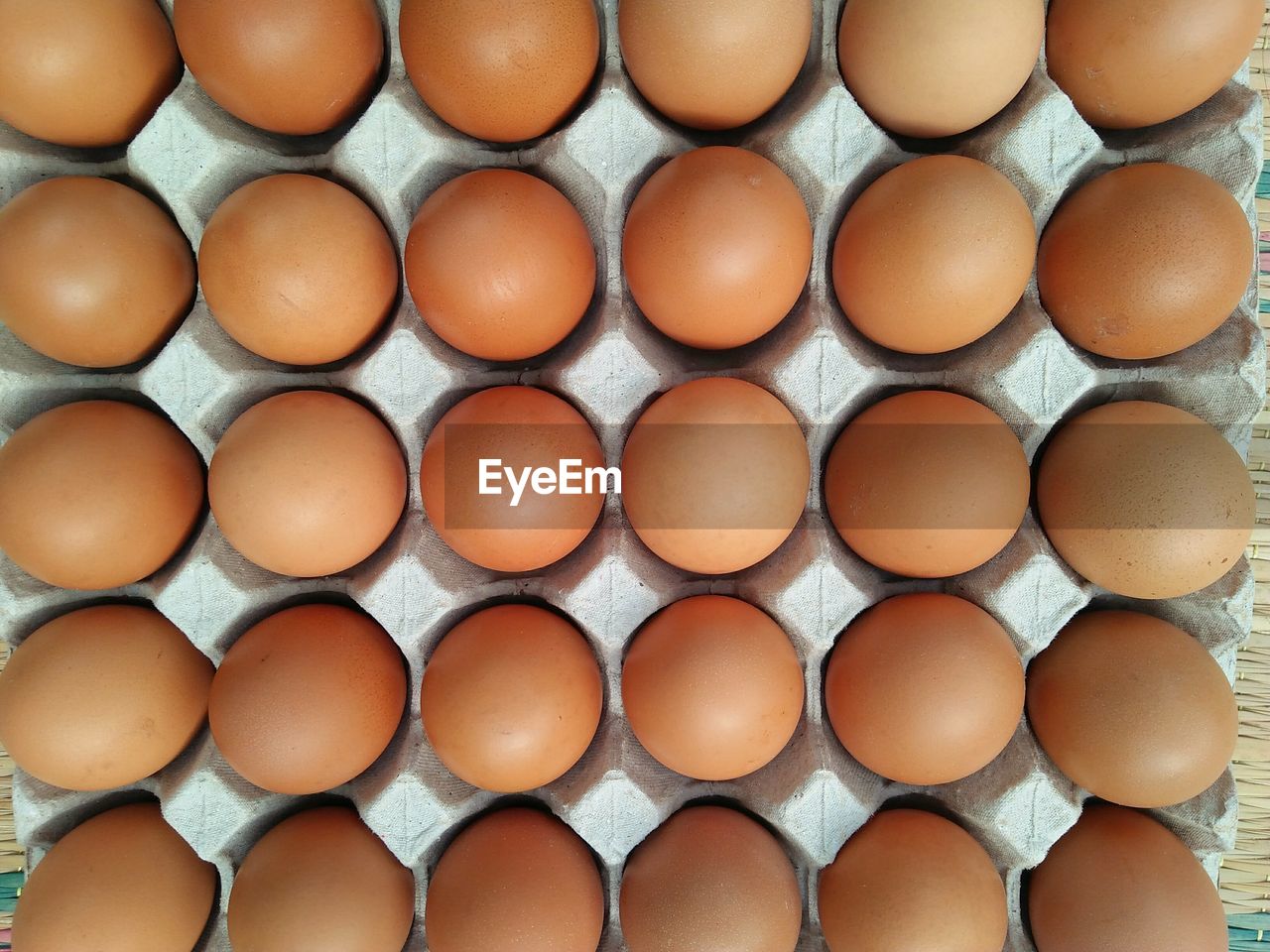 Full frame shot of brown eggs in crate