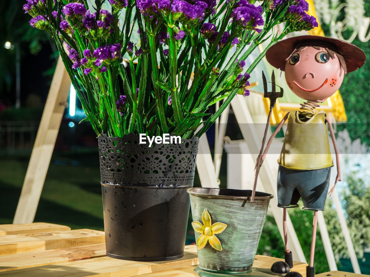 Close-up of figurine by potted plant on table