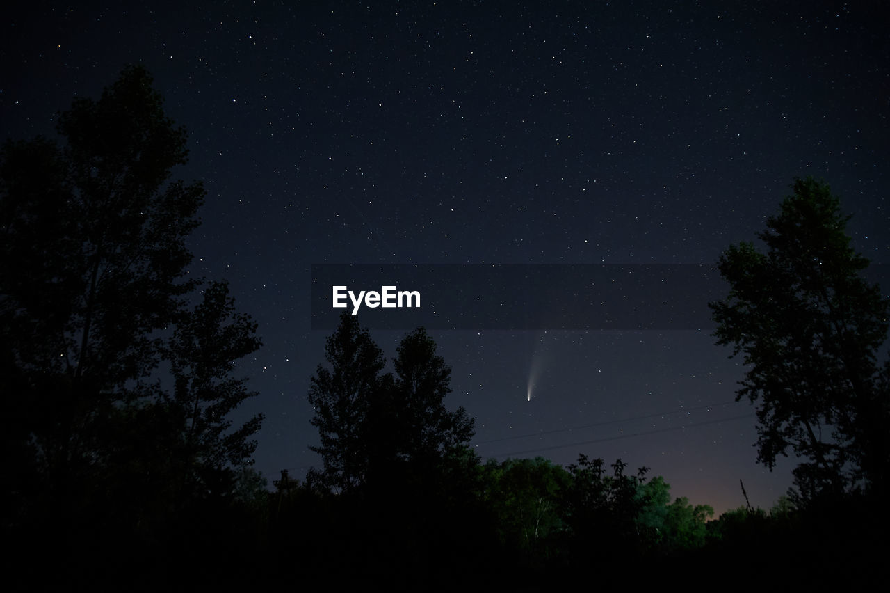 Comet neowise between trees view outside the city