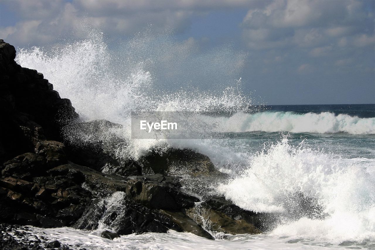 CLOSE-UP OF SPLASHING WATER AGAINST SKY