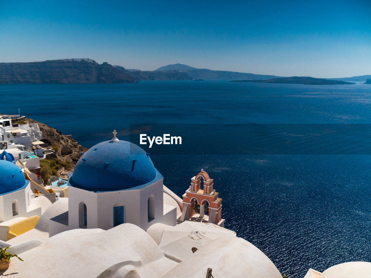 Panoramic view of sea against blue sky with church in the foreground