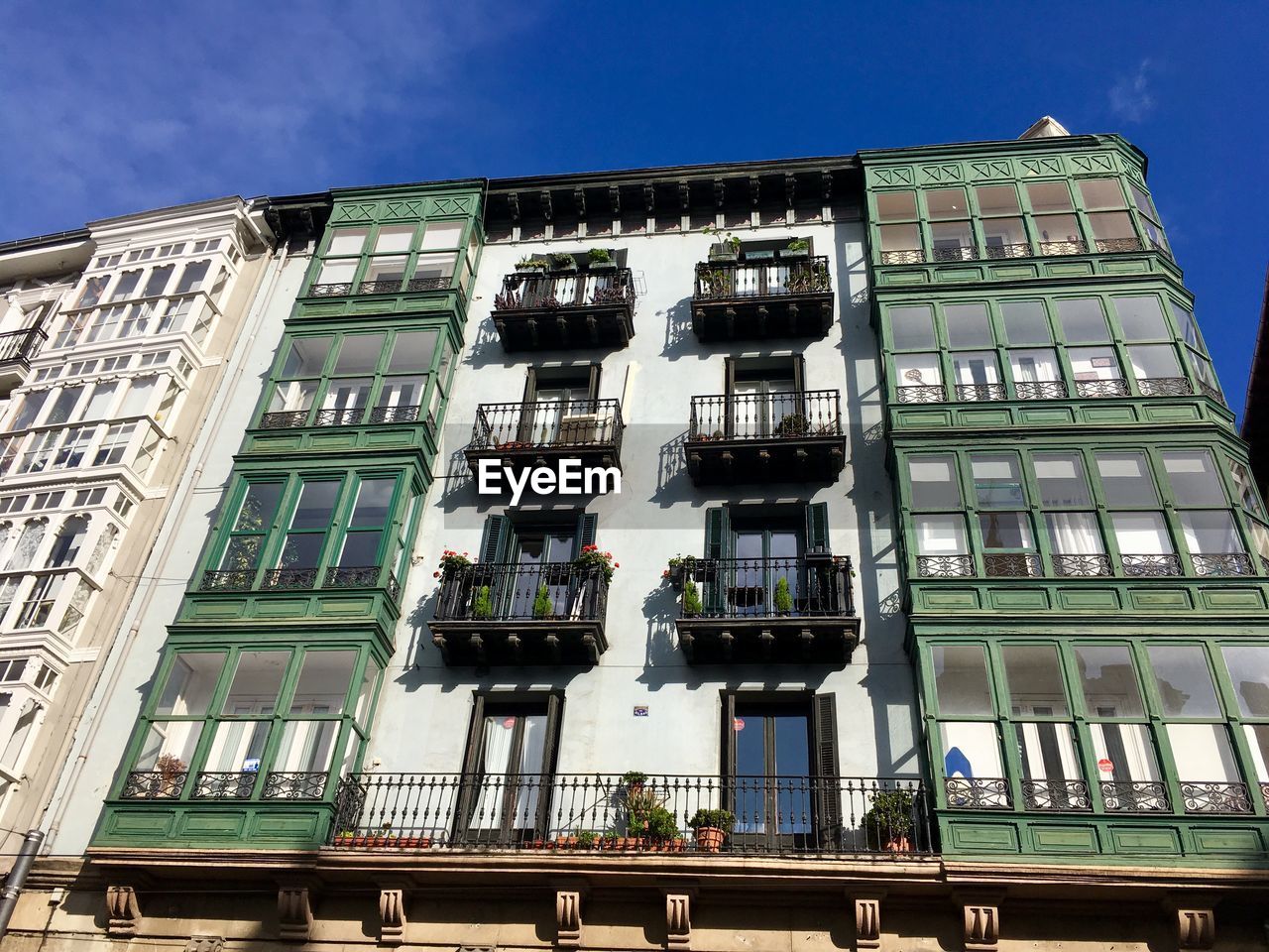 LOW ANGLE VIEW OF BUILDINGS AGAINST BLUE SKY