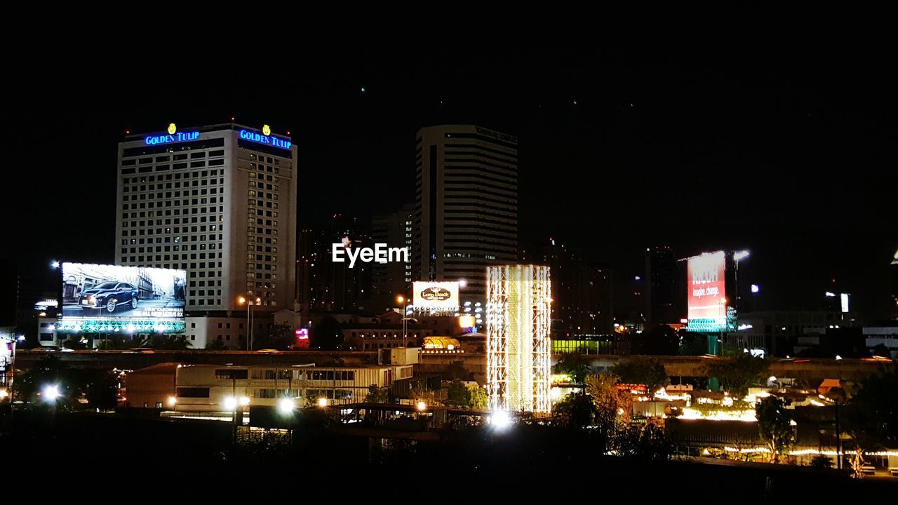 VIEW OF ILLUMINATED CITYSCAPE AT NIGHT