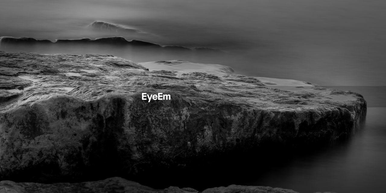SCENIC VIEW OF SEA AGAINST ROCK FORMATION