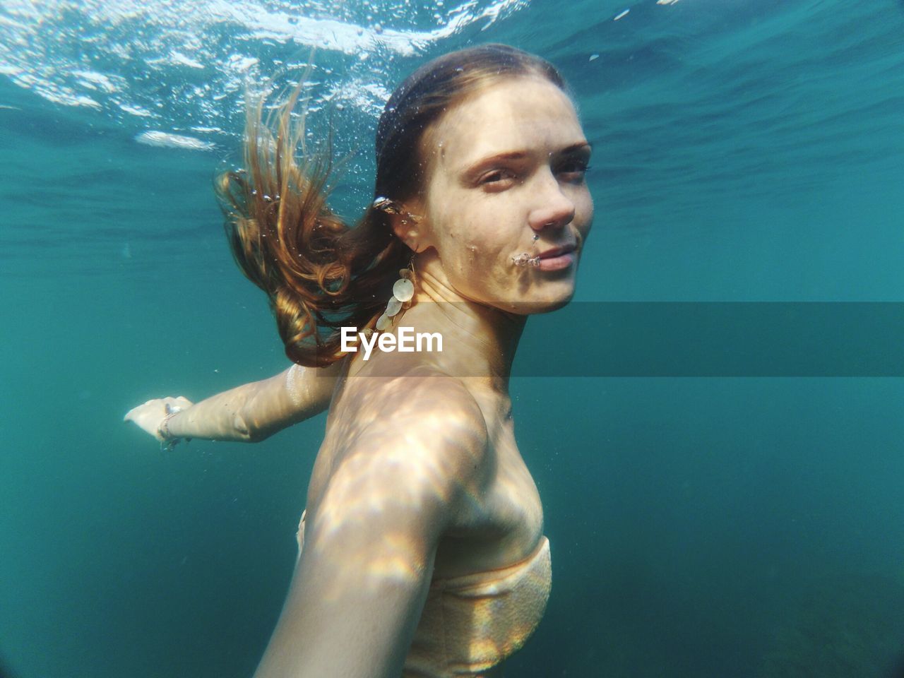 Side view portrait of woman swimming undersea