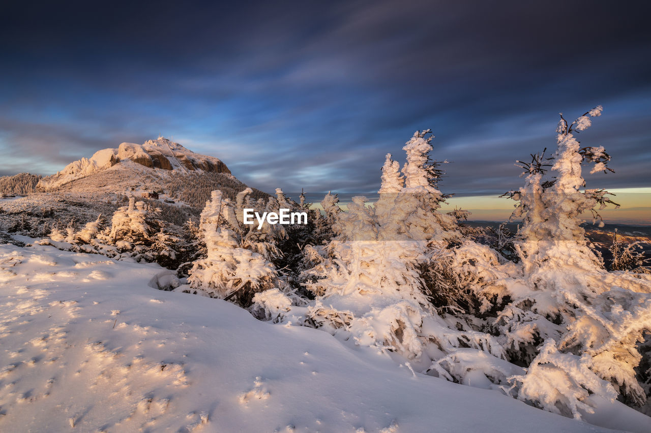 Snow covered mountains against sky during sunset