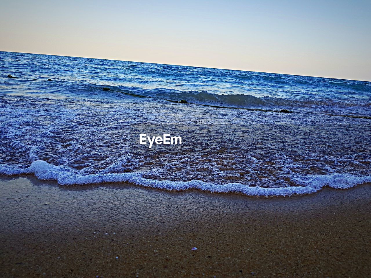 SCENIC VIEW OF SEA AGAINST CLEAR SKY AT SUNSET