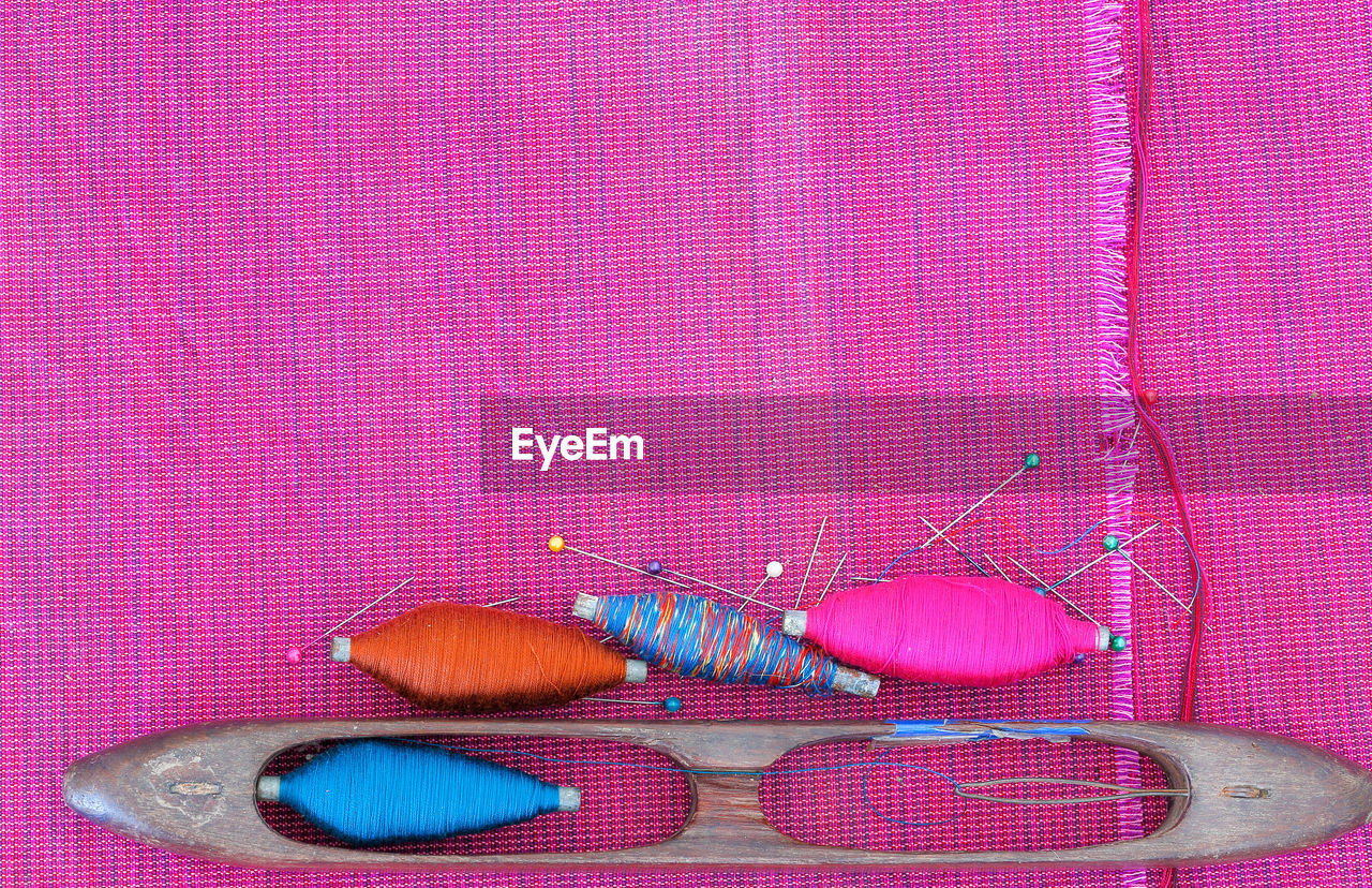 HIGH ANGLE VIEW OF MULTI COLORED PATTERN ON PURPLE FABRIC