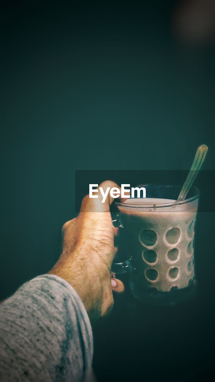 Close-up of hand holding coffee cup