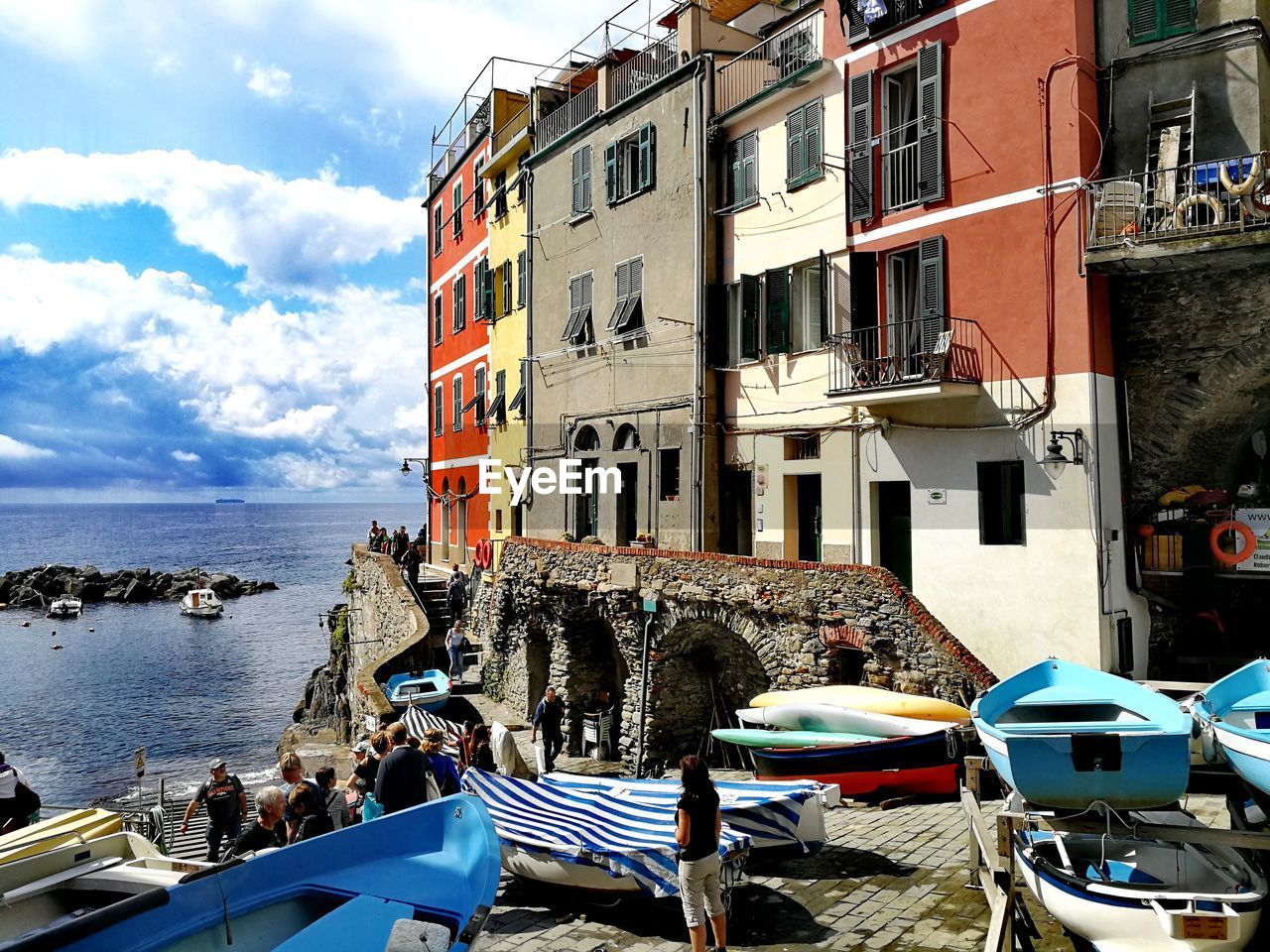 People by boats moored at sea