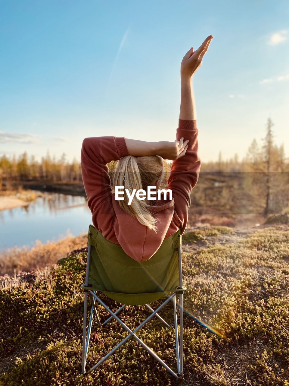 Rear view of woman sitting on field