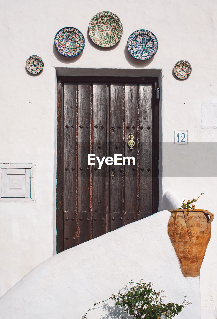 Potted plants on closed door of building