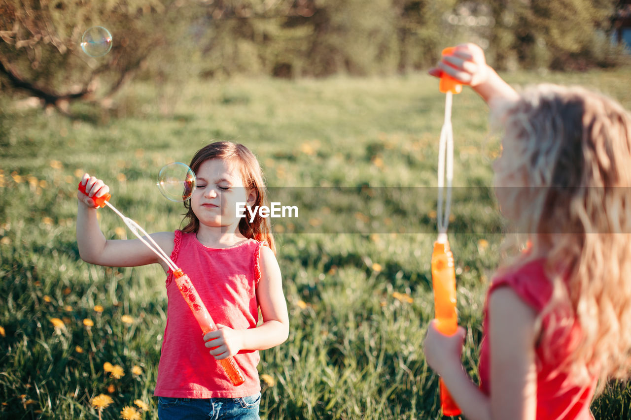 Happy girl holding plant on field