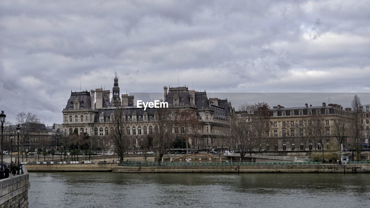 Buildings in city against cloudy sky