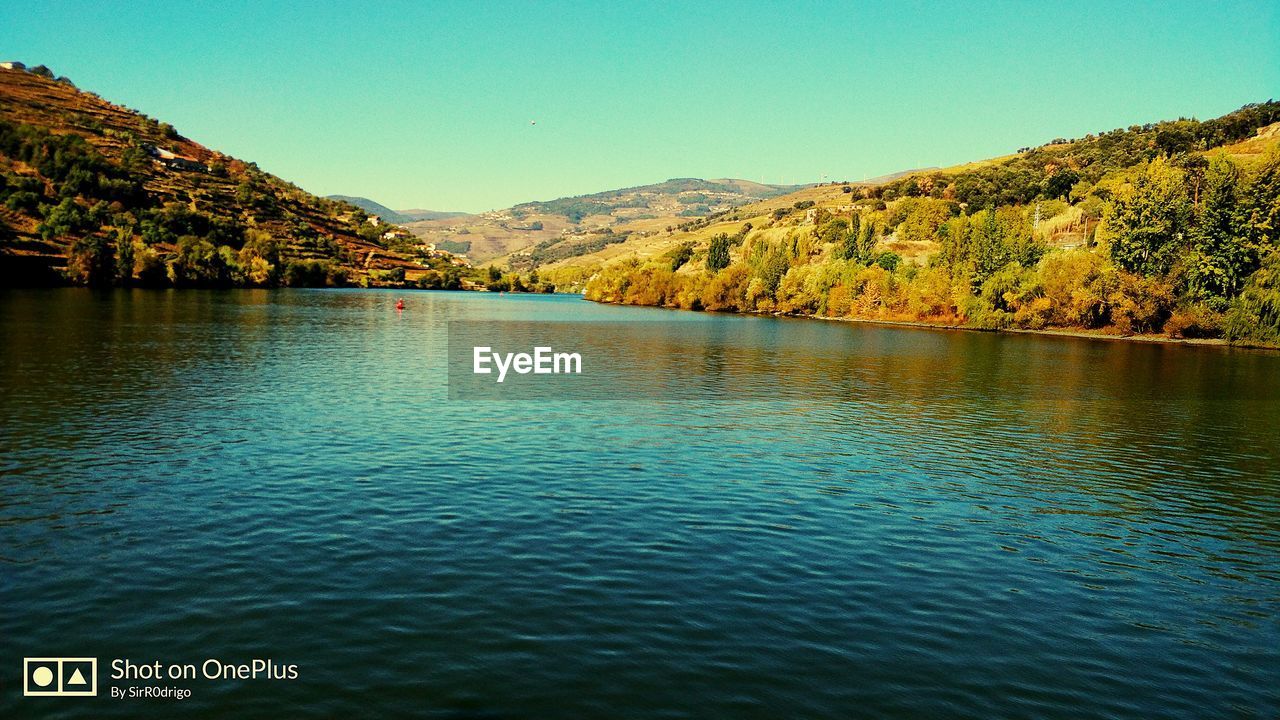 SCENIC VIEW OF LAKE BY MOUNTAINS AGAINST CLEAR SKY