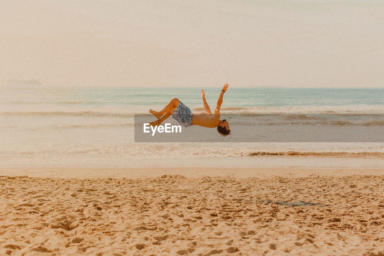 Full length of man jumping on beach