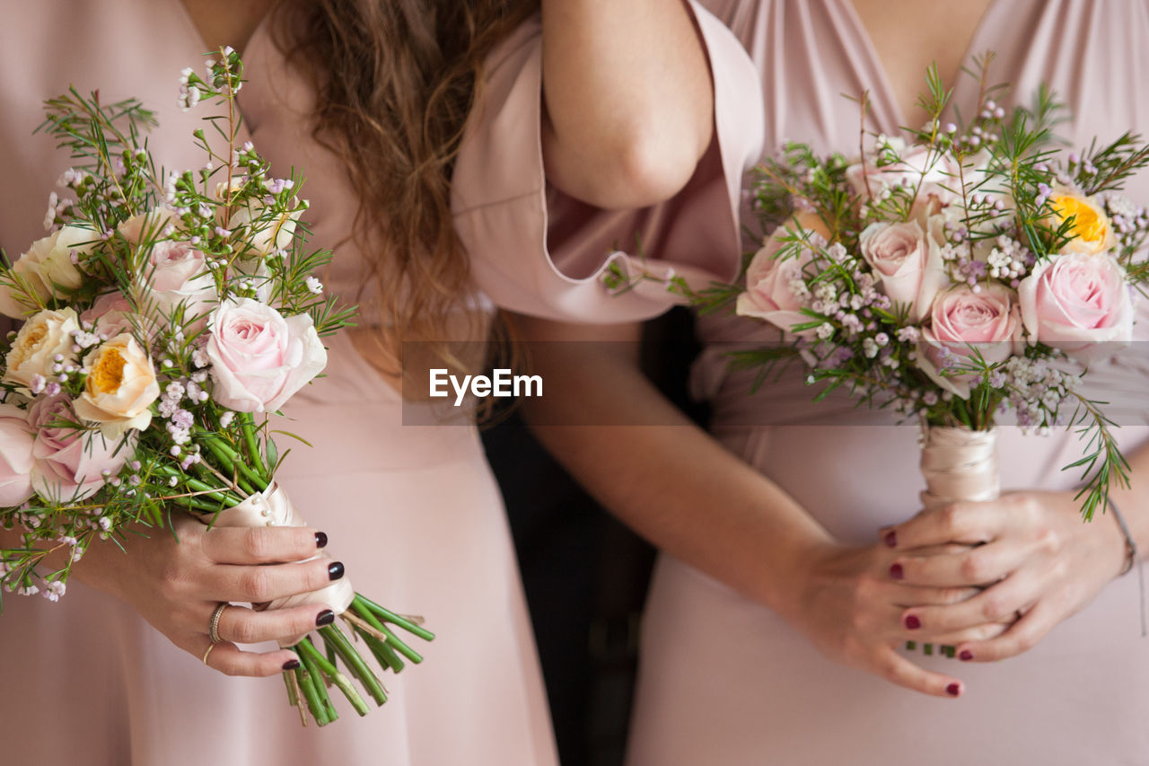 Midsection of women holding bouquets