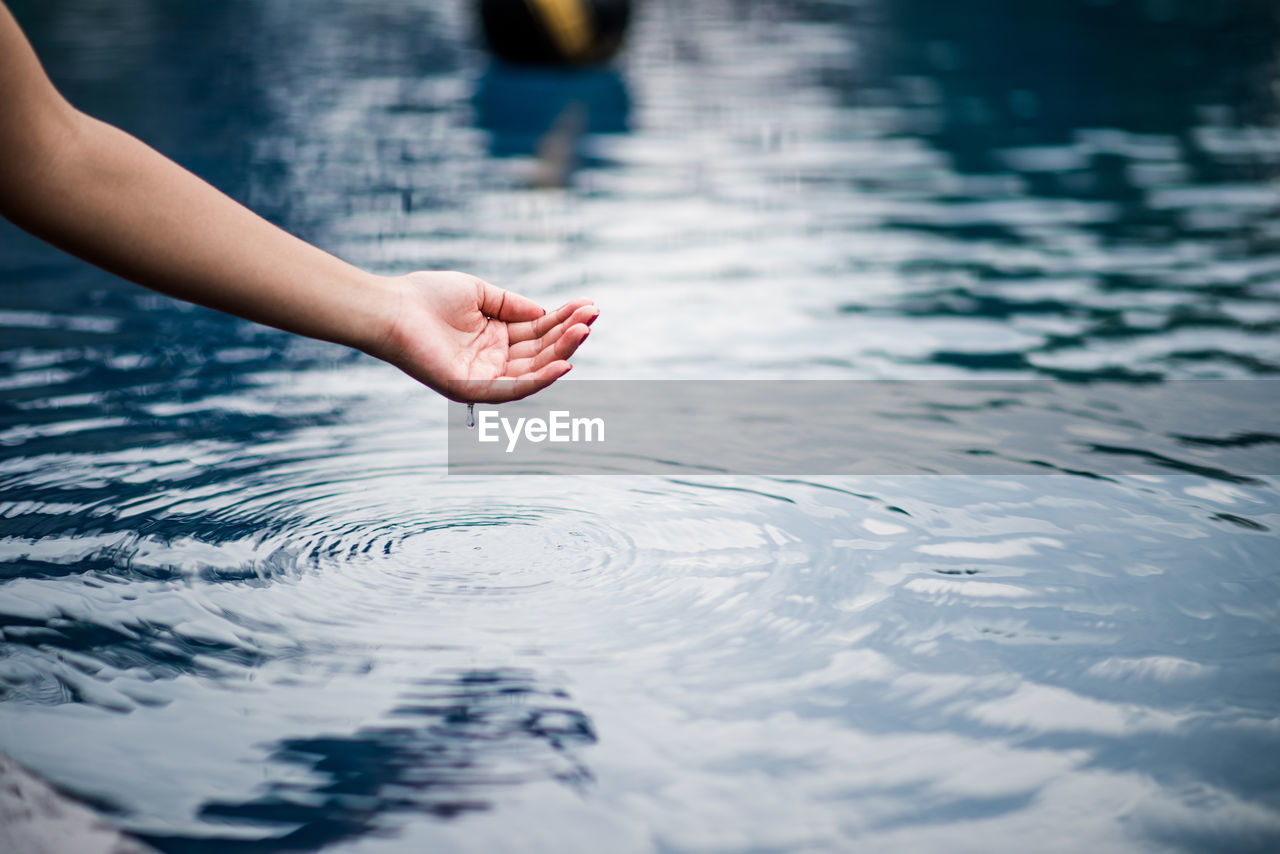 Cropped hand by lake