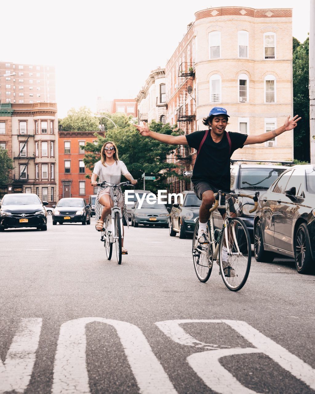 YOUNG WOMAN RIDING BICYCLE ON STREET