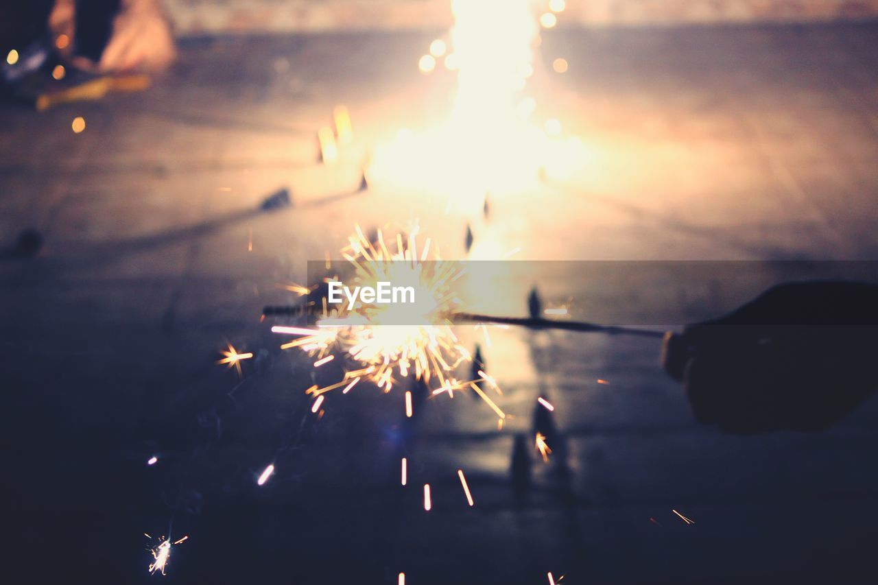 Close-up of hand holding sparkler at night