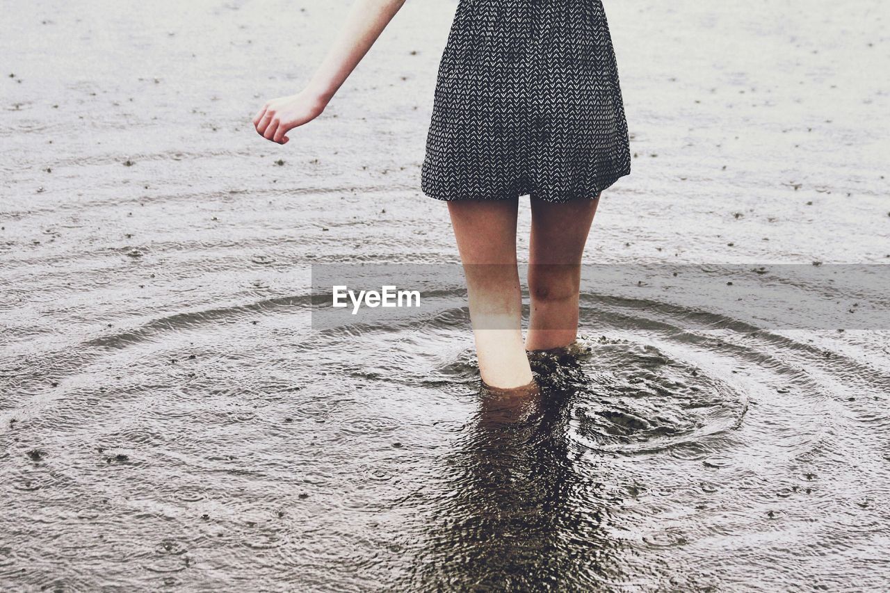 Low section of woman standing in lake