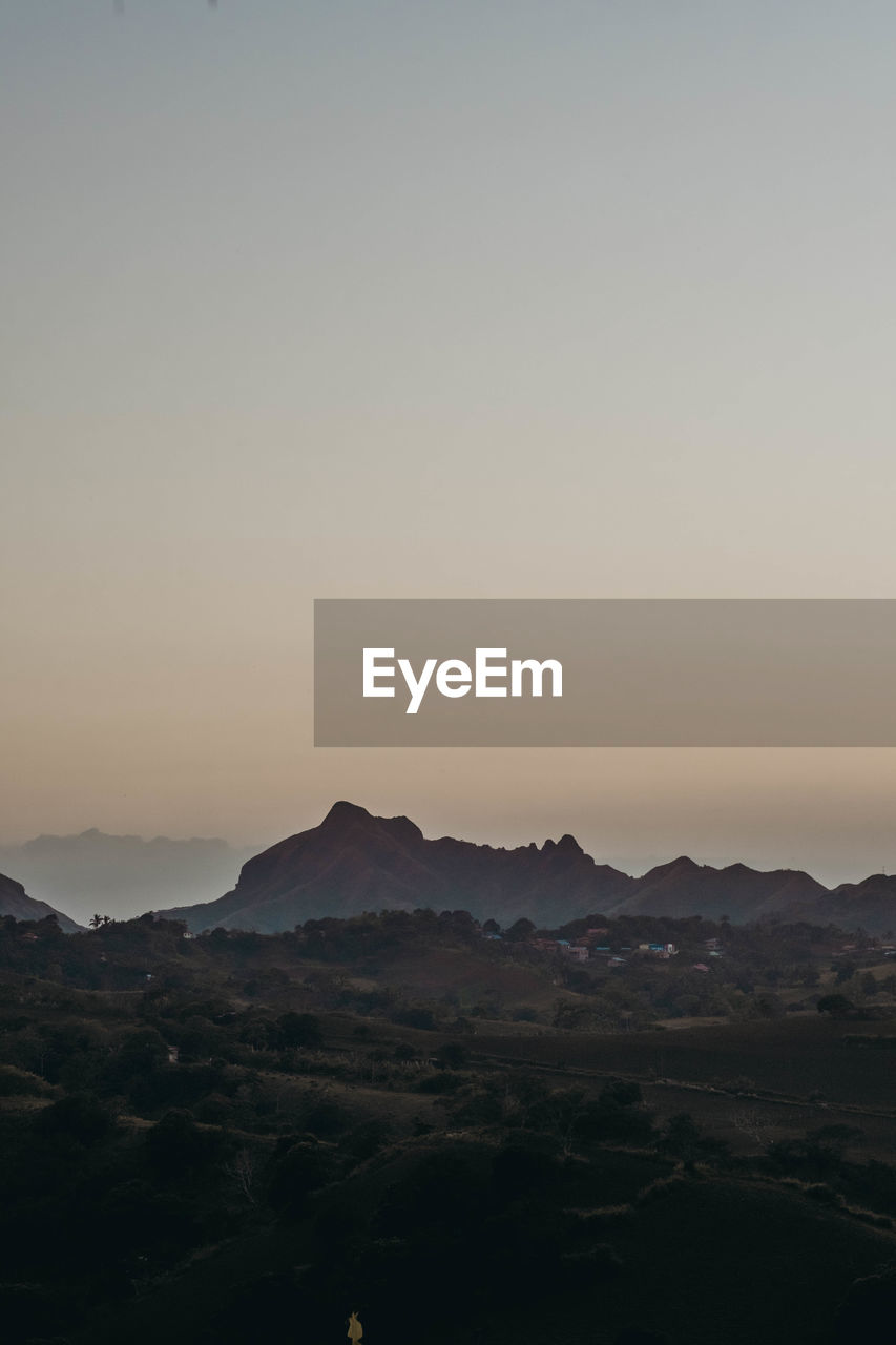 SCENIC VIEW OF SILHOUETTE MOUNTAINS AGAINST CLEAR SKY DURING SUNSET