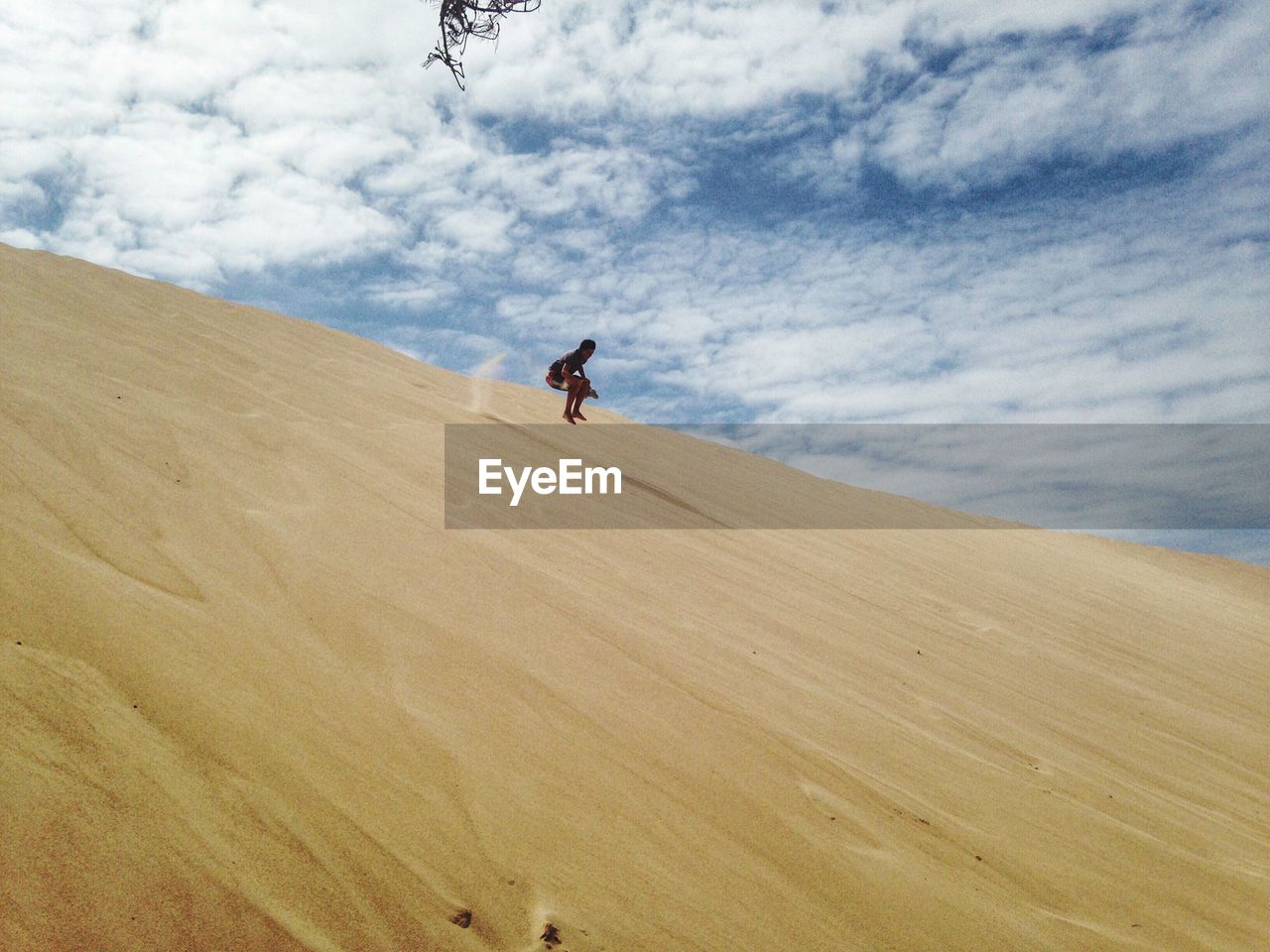 MAN ON SAND DUNE IN DESERT