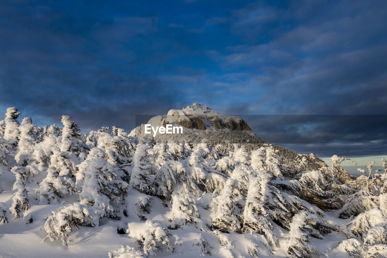 Scenic view of snow covered mountains against blue sky