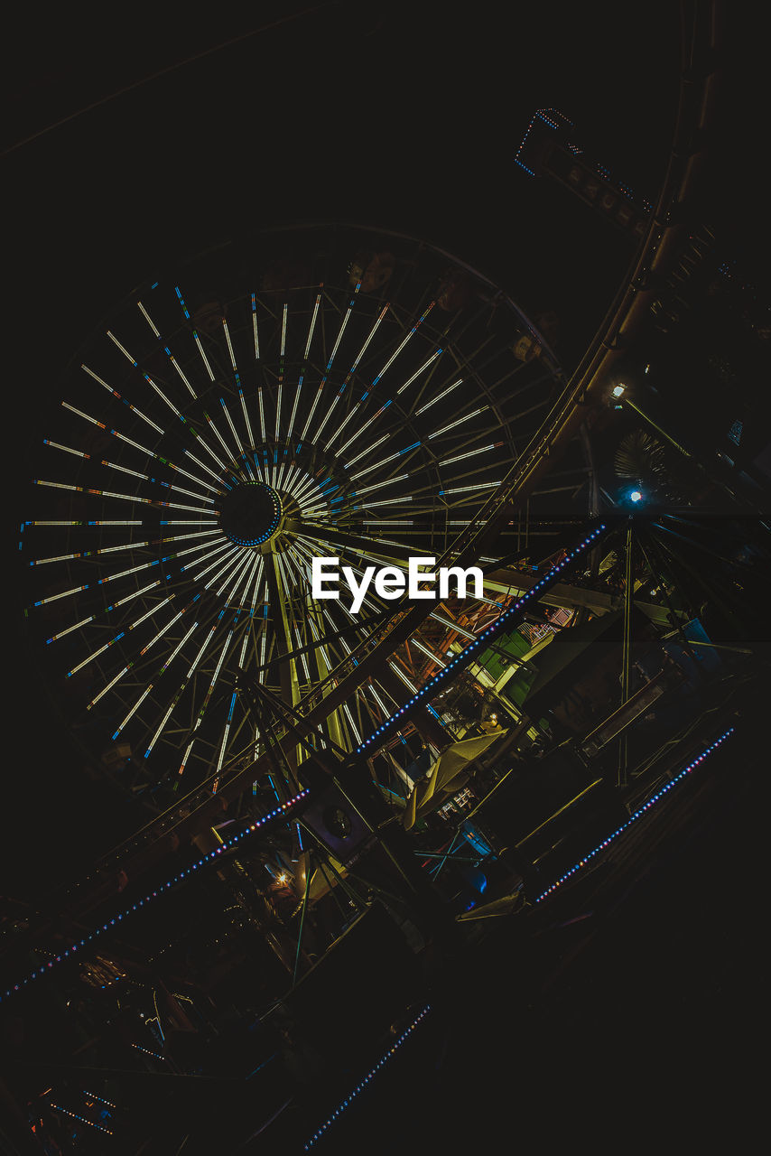 LOW ANGLE VIEW ILLUMINATED FERRIS WHEEL AT NIGHT