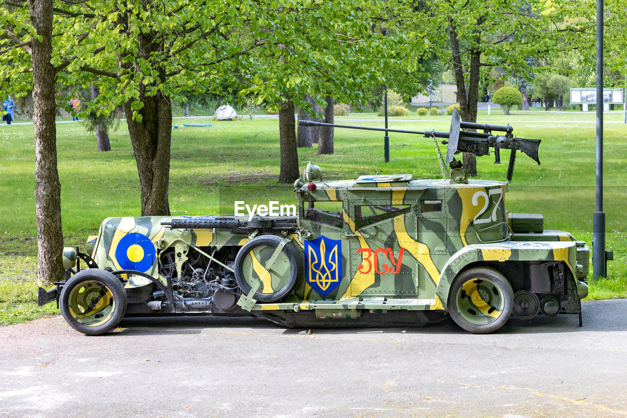 An armored car painted in camouflage with the coat of arms of ukraine under the emblem of ukraine