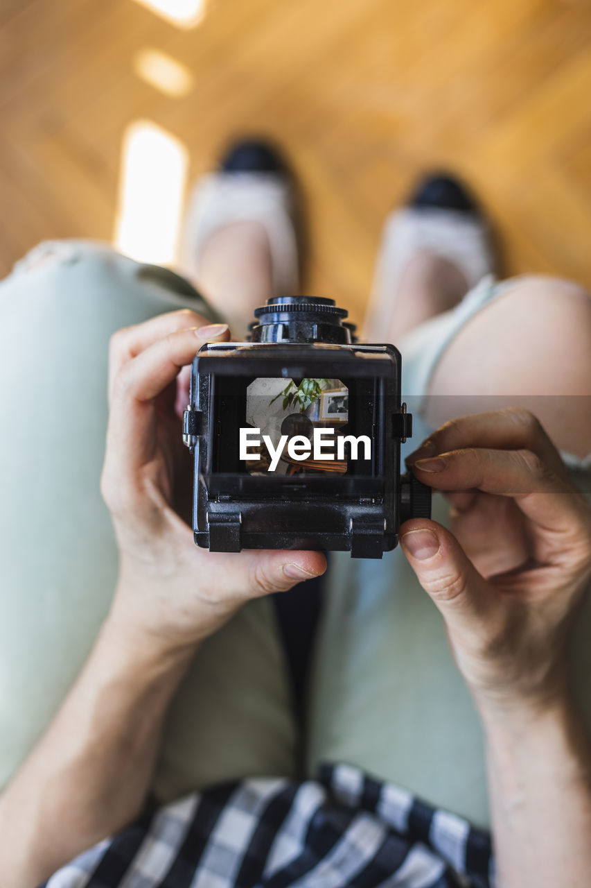 Top view of a girl takes a photo with her medium format camera.