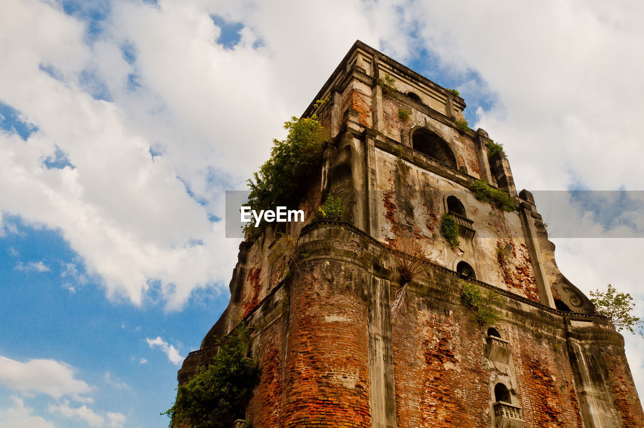 Low angle view of old building against cloudy sky